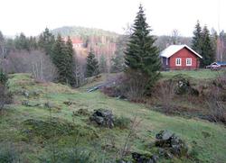 Øvresaga og tufter etter låven ved «Bygningen» i forgrunnen, med Rausjø skole i bakgrunn