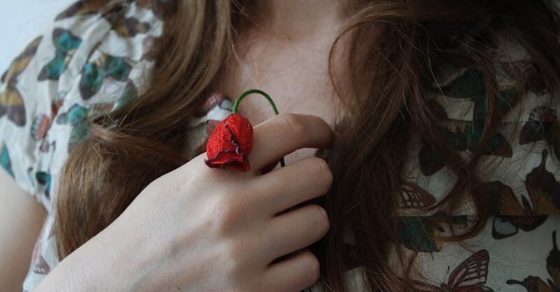 Bilde av en jente som holder en død blomst