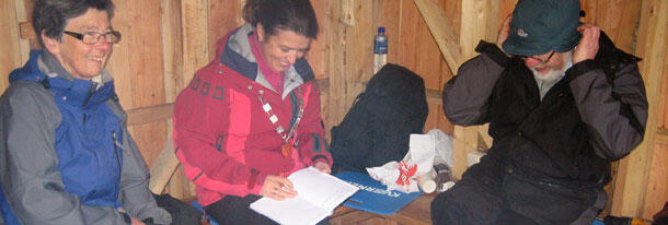 Ordføraren skriv i gjesteboka i gapahuken på Lundarstøl.