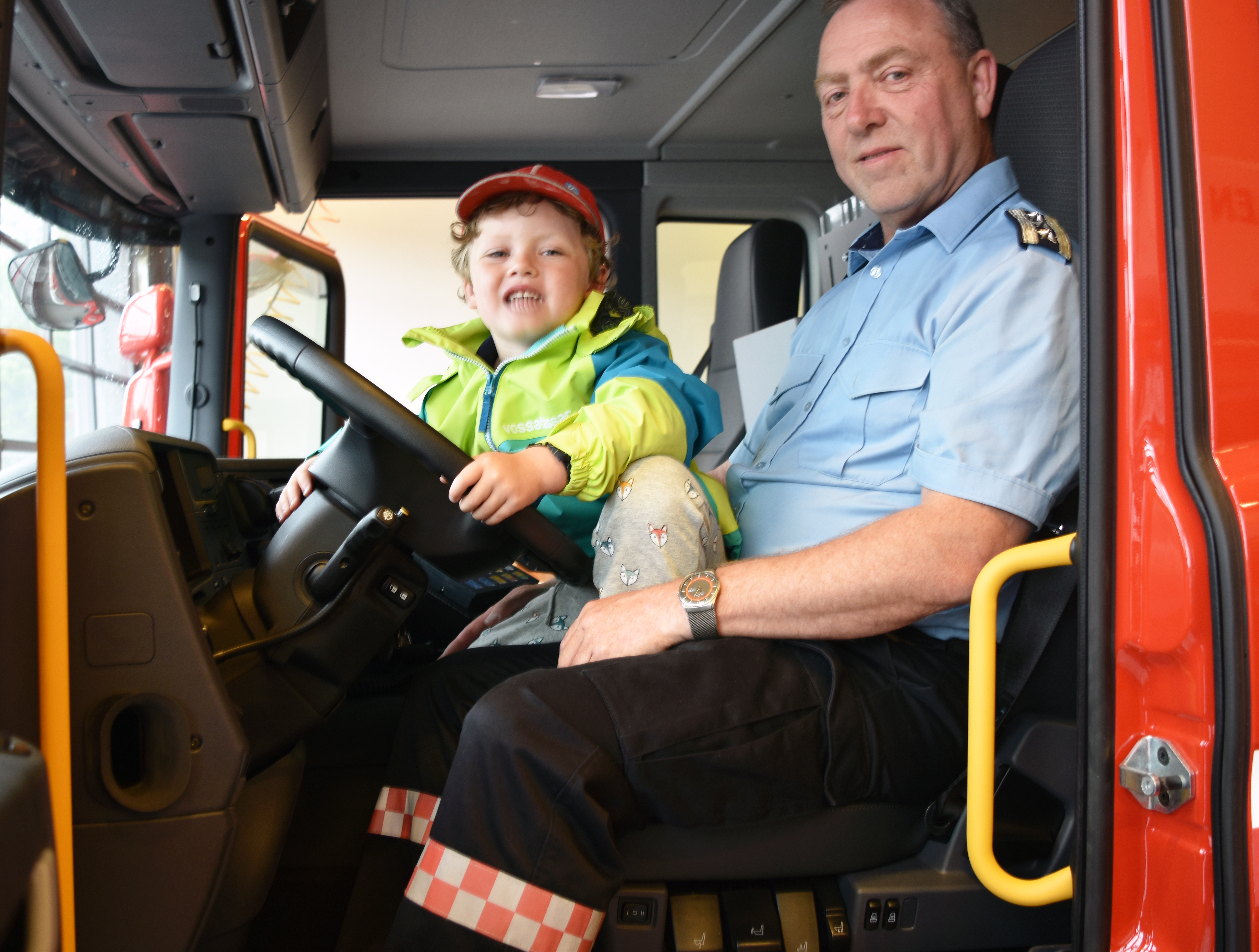 Brannsjef Børge Presthaug og barnebarnet Olve Ohnstad Presthaug (4) prøvesit den nye brannbilen.
