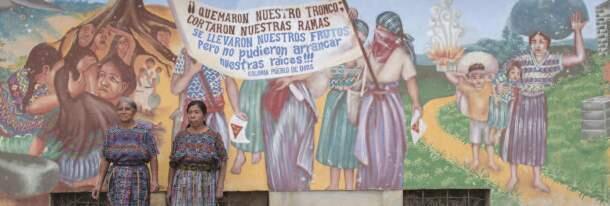 Guatemalske damer forran ein plakat