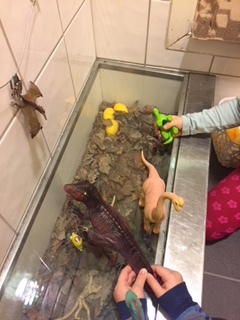 Dinosaurar i ein vask, små hender leikar