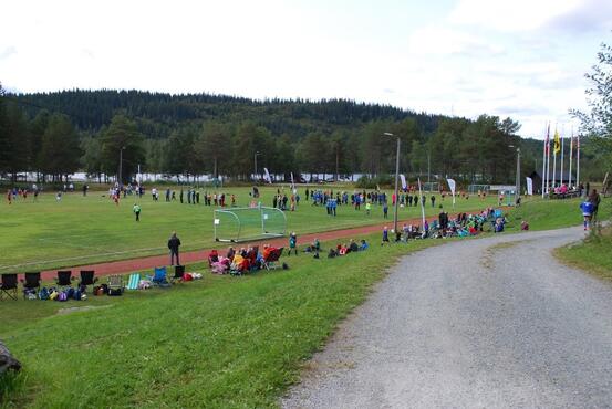 Bilde av fotballbanen i Høydalsmo med personar på og utanfor banen