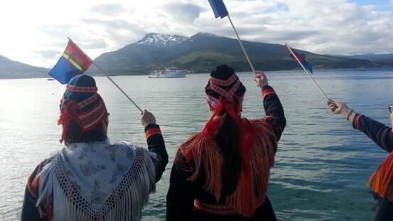 To samiske kvinner som utover Tjeldsund og vifter med samisk flagg.