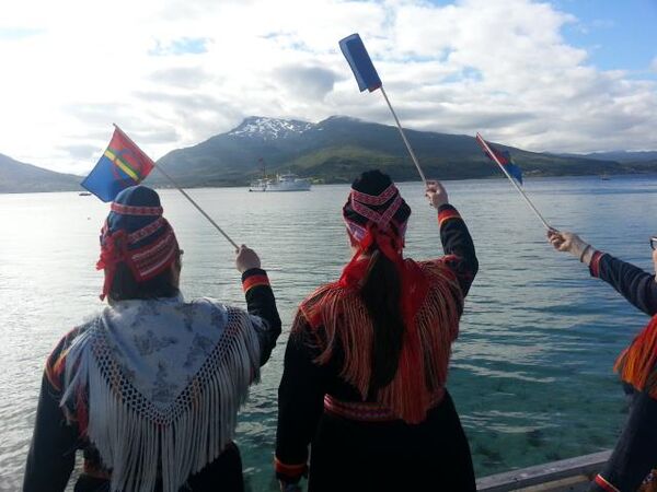 To damer med samisk flagg. Utsikt over Tjeldsundet og Kongeskipet