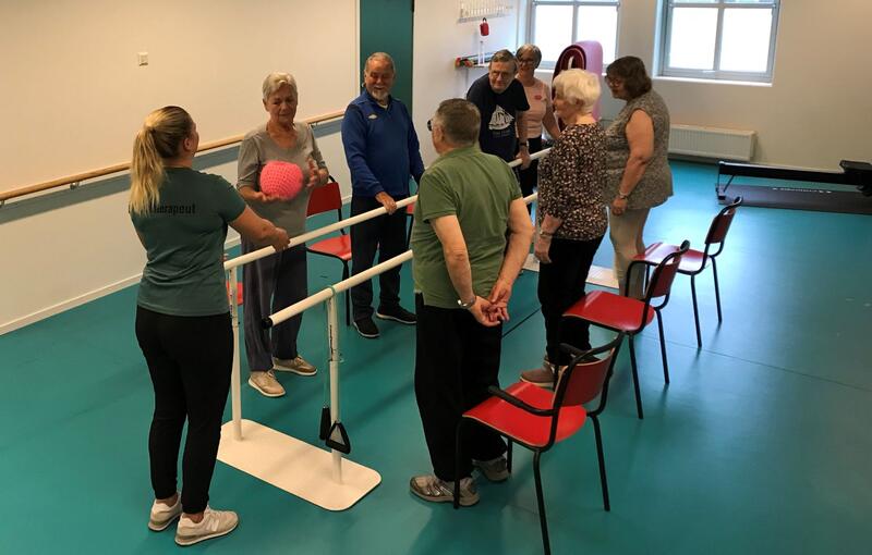 folk på rehabilitering, står i ring med instruktør. foto