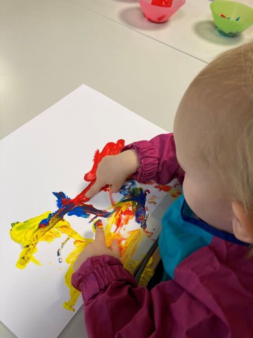 Barn maler med fingrane