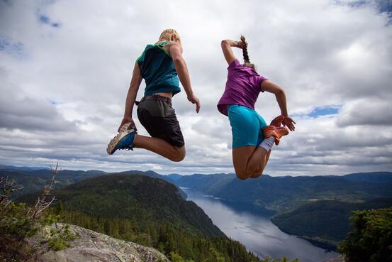 Utsikt over Lårdalsstigen med to personar som hoppar - bilde