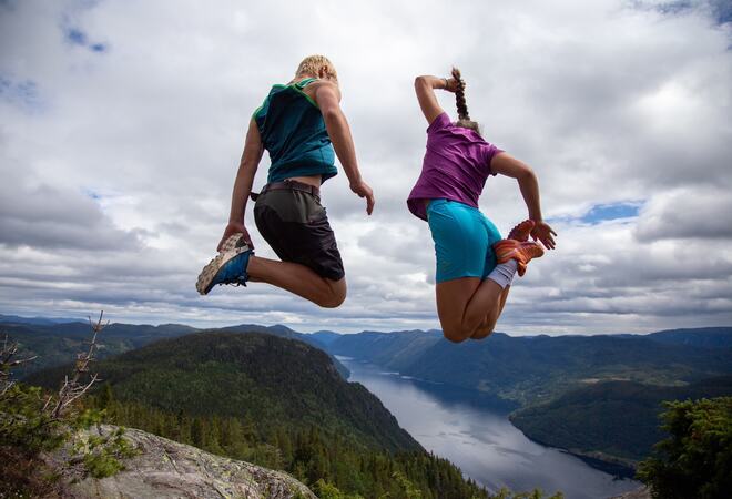 Utsikt over Lårdalsstigen med to personar som hoppar - bilde