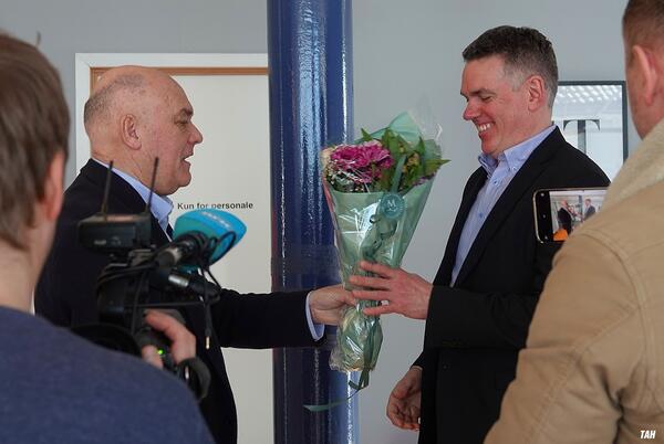 Mann overleverer blom til anna mann. foto
