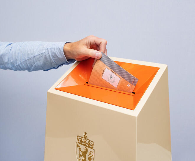 Legger Stemmesedel i urne