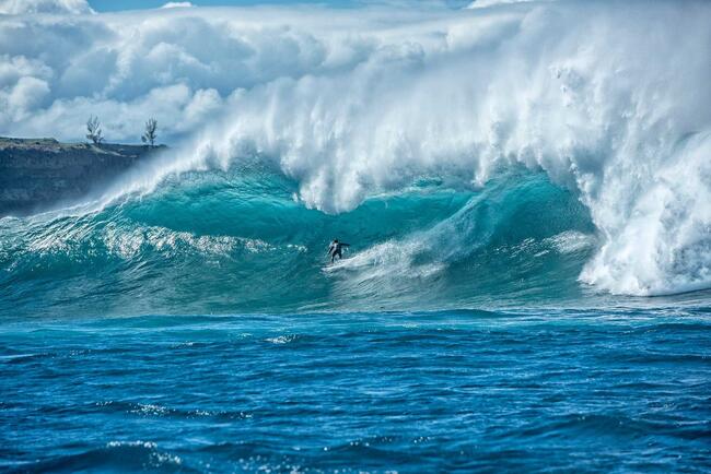 Bilde av en person som surfer i høye bølger