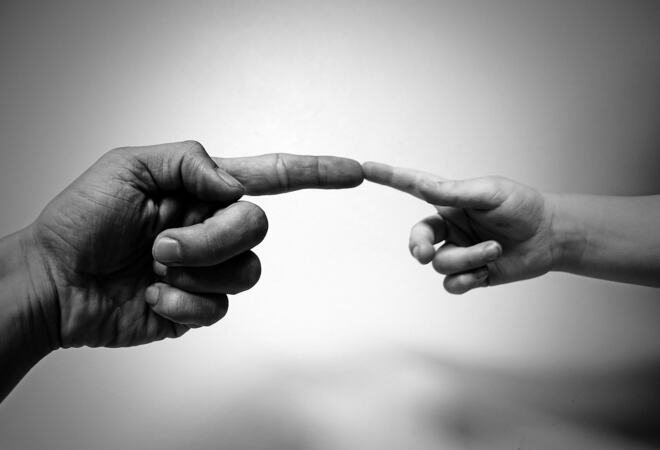 Bilde av hendene til to personer hvor pekefingrene møtes