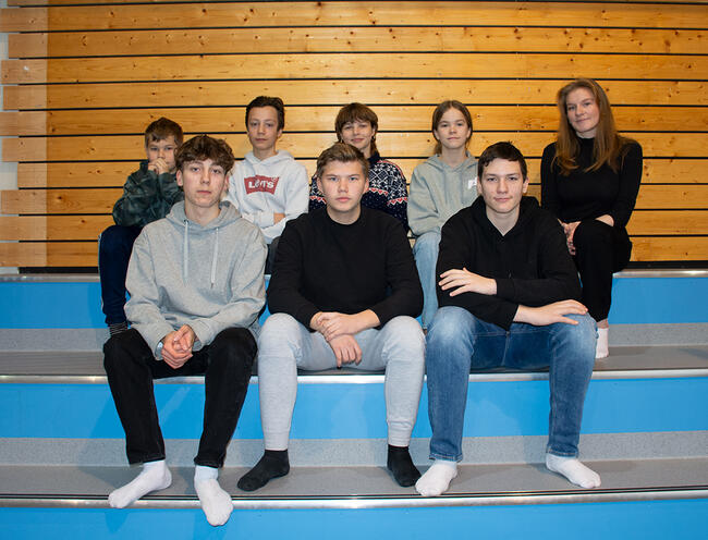 Ungdomer sitter på benk i Hamarøyhallen