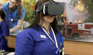 jente i blå uniform har VR briller på seg