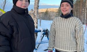 To jenter står ute med ski
