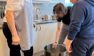 En lærer og to elever lager bidos på skole kjøkkenet