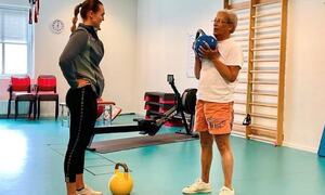 to damer står i treningsrom, eldre dame held ein kettlebell