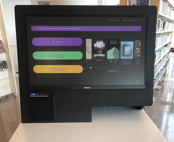 Bilde av en automat med skrift og knapper der du kan låne bøker osv.