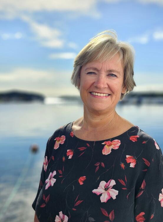 Portrettbilde av kommunedirektør, Guri Ultveit-Moe ved Lillesand havn på en solskinnsdag.