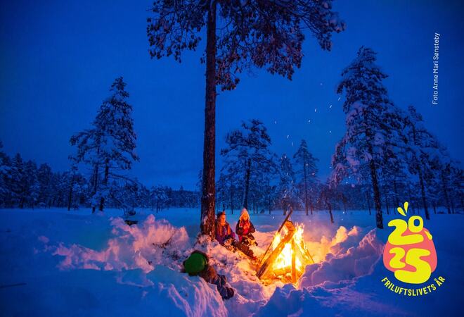 Snølandskap med et stort bål som brenner.