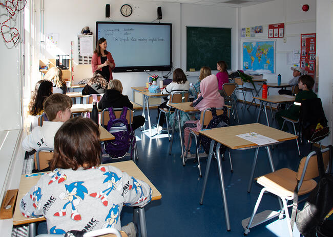 Elever sitter i klasserommet og hører på læreren