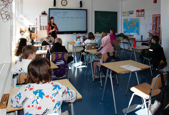 Elever sitter i klasserommet og hører på læreren