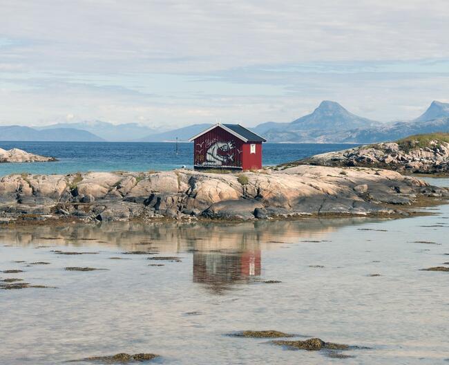 Rødt hus på Tranøy med graffiti på