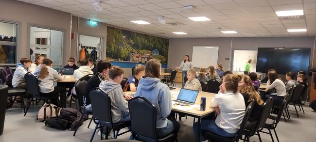 Elever sitter rund boret
