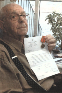 Sigurd A. Carlsen viser fram diplom og medalje