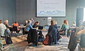 Masse folk sitter i salen og ser på presentasjon
