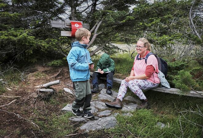 to barn på tur i skogen saman med ei dame