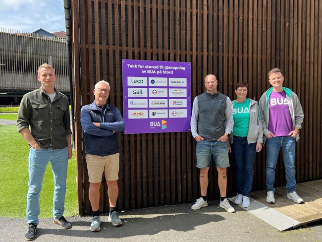 Bildet viser BUA sin stab og tre lokale sponsorar utanfor den sjølvbetente stasjonen ved Stord kulturhus.
