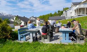 Bilde viser flere personer som er samlet rundt noen benker
