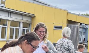 Barn og voksne spiser frukt ute