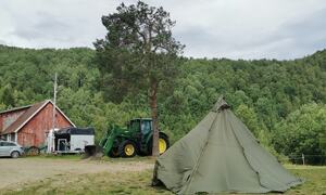 Lavvo ute, traktor i bakgrunn