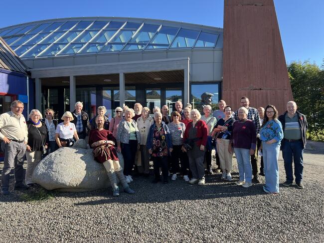 Masse folk poserer til bilde ved inngang til museet
