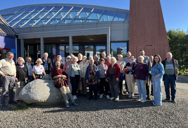 Masse folk poserer til bilde ved inngang til museet
