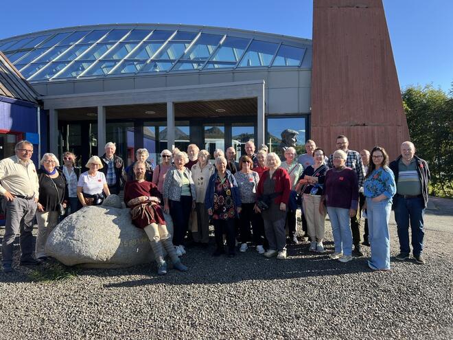 Masse folk poserer til bilde ved inngang til museet
