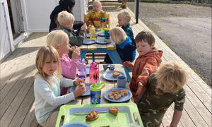 Barn rundt et bord og spiser