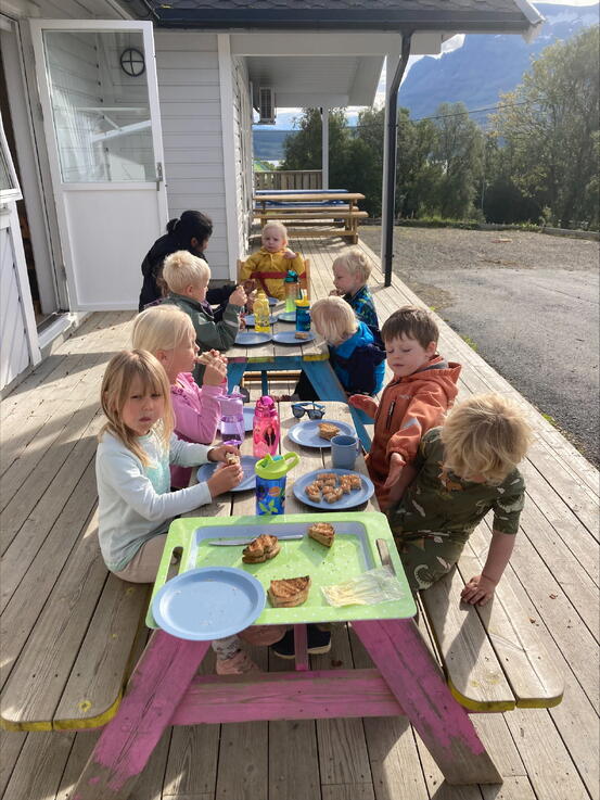 Barn rundt et bord og spiser