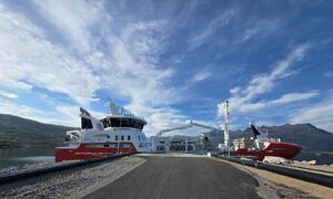 Båten som ligger til kai ved Nordlaks. Veggfjellet i bakgrunn