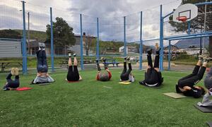 Folk ligger på ryggen med føtene oppe