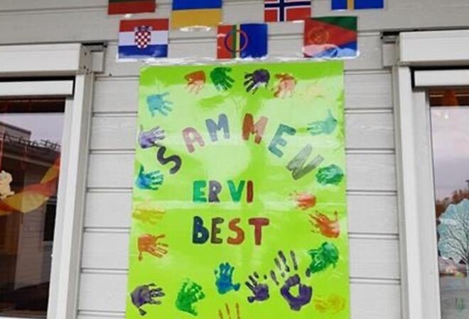 Bilde viser plakat med farger, tekst og barnehender