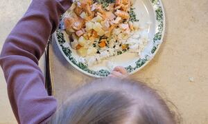 Bildet viser et barn som spiser laks