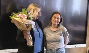 barnebarnet til Thorill Paulsen mottar blomster på vegne av bestemora