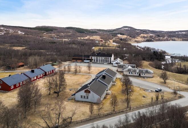 Oversiktsbilde av Elvemo eiendom, som viser bygningsmassen og utearealene.